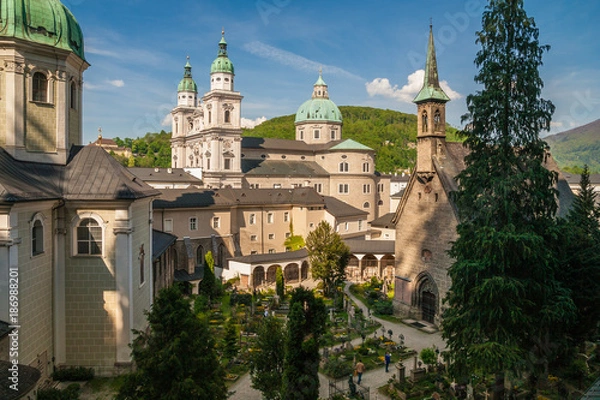 Fototapeta St. Peter's Cemetery in Salzburg, Austria which is one of the oldest and most beautiful cemeteries in the world. In the background you can see the Salzburg Cathedral.