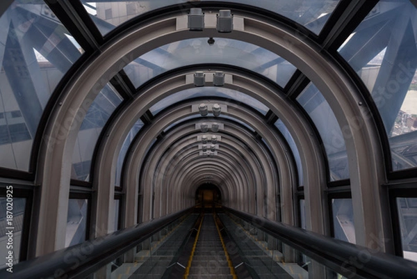 Fototapeta Diminishing perspective in a futuristic escalator tube, where does this tunnel bring us to?