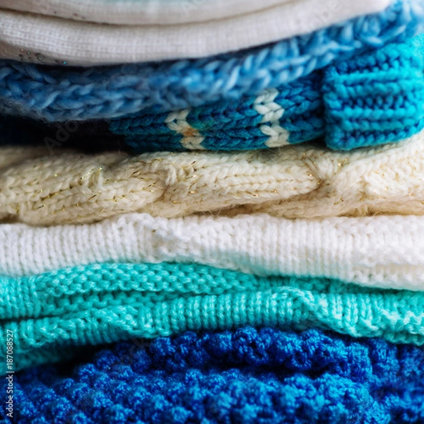 Obraz Knitted things. Sweaters are lying on a wooden table. Candles. Autumn. Cozy.