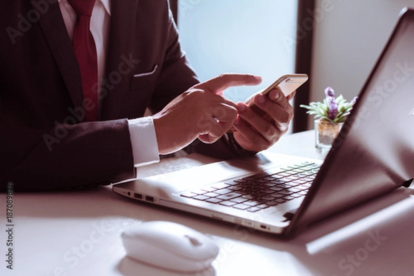 Fototapeta Business man, technology and internet concept, Close up of male hands with smartphone. Online shopping or banking concept, credit ,debit. Businessman using smart phone with conputer laptop on desk.