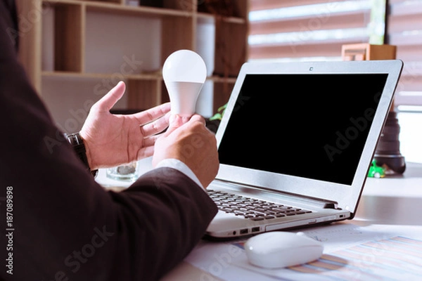 Fototapeta Businessmen holding light bulb as a creative model. Bright idea in hand of businessman concept.The power of creativity, technology, innovation, new business to success in the future concept.