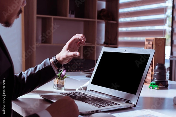 Fototapeta Business are using laptop on desk indoors with afternoon hard light.The boss is making a problem gesture with work or business.