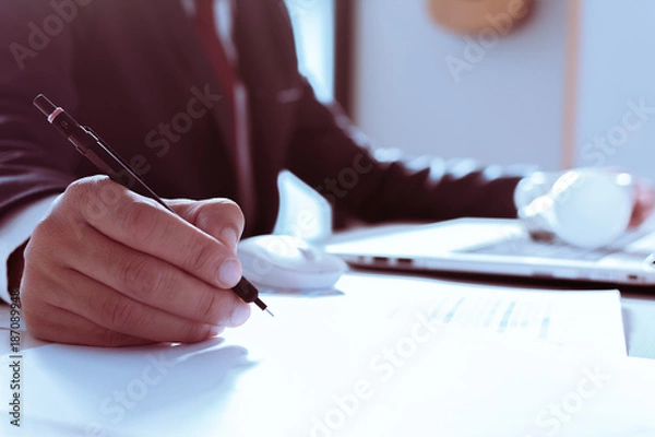 Fototapeta Close up of hand's Businesswomen analyzing investment charts on the desk. Pen in hand. over light.