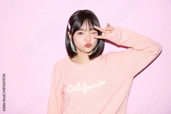 Obraz ピンク背景でキュートなポーズをする若い女性のポートレート