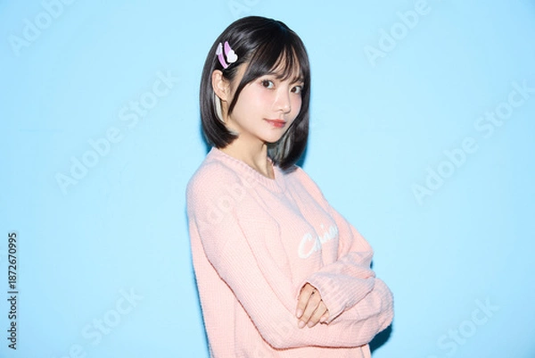 Obraz ブルー背景でキュートなポーズをする若い女性のポートレート