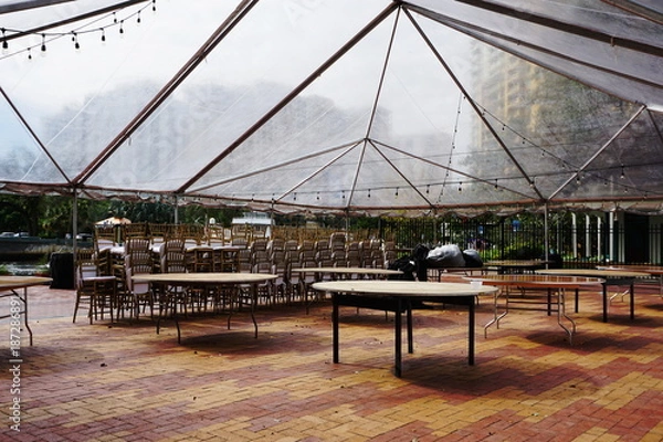 Obraz Clear Tent Event Setup with Stacked Chairs in Urban Setting