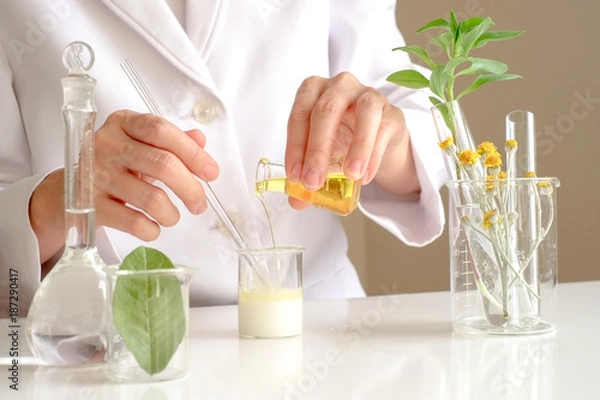 Fototapeta the scientist,dermatologist testing the organic natural product in the laboratory.research and development beauty skincare concept.blank package,bottle,container .cream,serum.