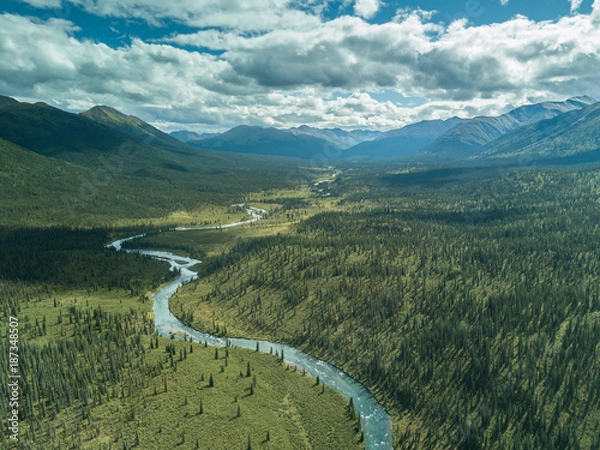 Obraz Middle of the day. The sun is high and casts clouds shadows all over the trees in this vast and remote land. An untouched river flows in northern British Columbia with nothing but mountains and trees.