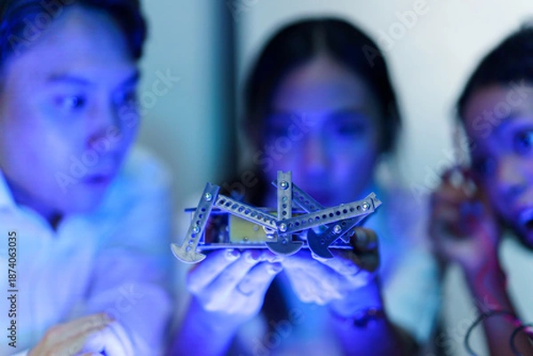 Obraz Engineering students testing robotic hand prototype with electronic tools