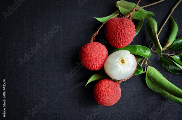 Fototapeta Fresh fruit Lychee on black clothing background, top view photo, copy space for text