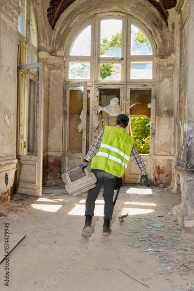 Obraz Reflective dressed worker moves through corridor during repair