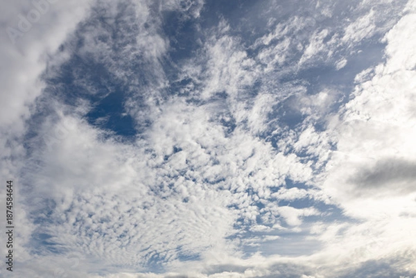 Obraz White clouds across bright blue sky.