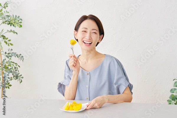 Obraz リビングで柿を食べる女性