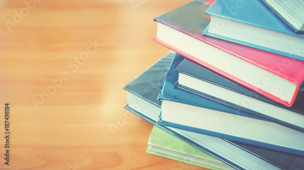 Fototapeta Book stack in the library room on wood desk and selective focus for business and education background, back to school concept