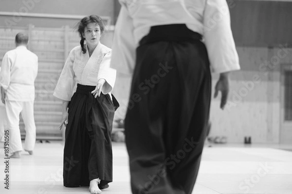 Fototapeta The participants of the training in special clothes of aikido hakama work out the methods of single combat