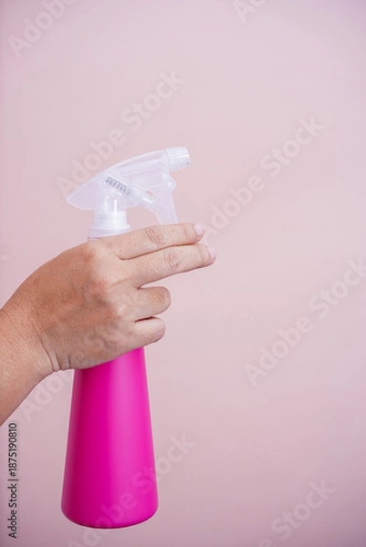 Obraz The hand holding the spray bottle.