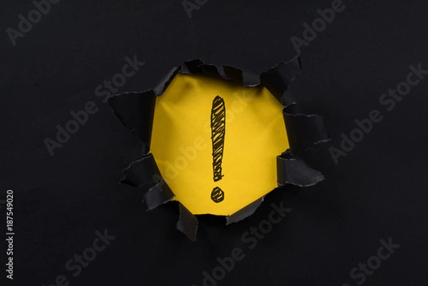 Fototapeta black torn paper revealing exclamation mark on yellow paper. exclamation mark background concept