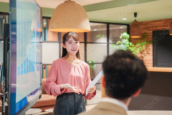 Obraz モダンオフィスでプレゼンをする若い女性