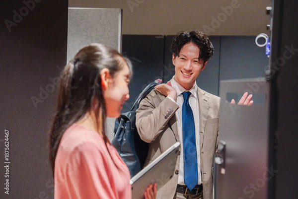 Obraz オフィスのロッカーで会話をする男女の会社員