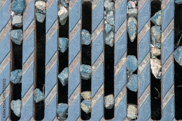 Obraz Kanaldeckel mit eingeklemmten Steinen.