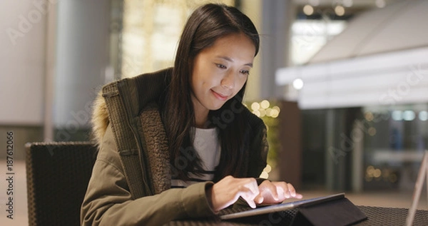 Obraz Woman use of tablet computer in coffee shop at night