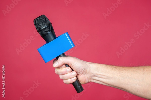Obraz Wireless microphone in hand on a red background