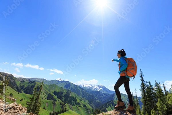 Fototapeta successful Hiker stand at cliff edge on mountain top