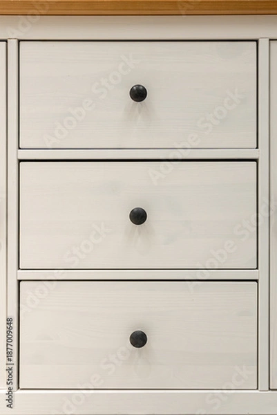 Obraz Three white drawers with round black knobs. Order geometry.