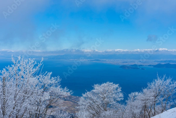 Obraz 霧氷に包まれた冬の琵琶湖と澄んだ青空の風景