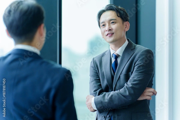 Obraz 景色を眺めるビジネスパーソンの背中