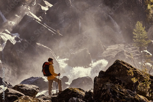Obraz Hiker hiking with backpack looking at waterfall