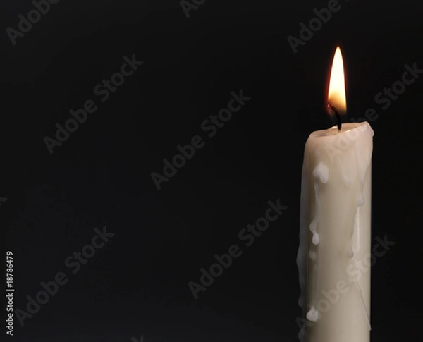 Fototapeta Burning candle over black. Is not isolated, just shot on black