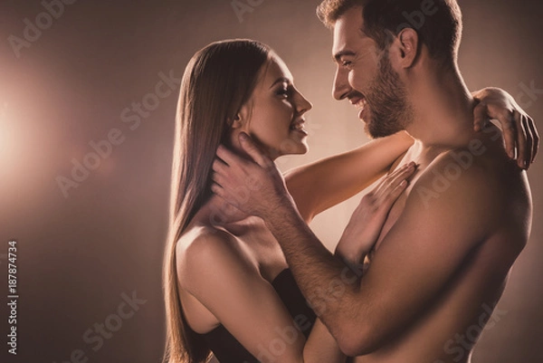 Obraz beautiful couple smiling and looking at each other, on brown