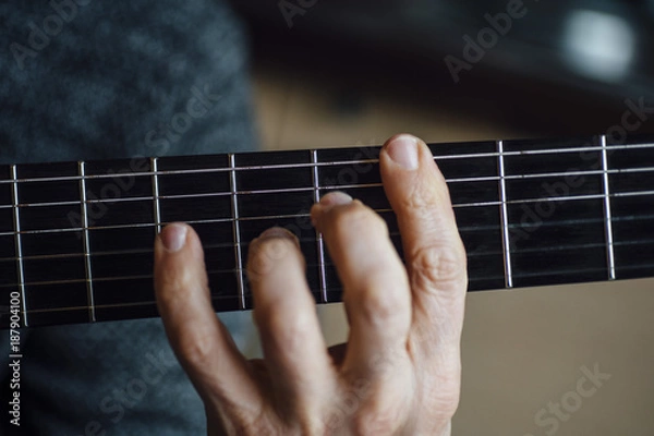 Fototapeta Elderly man playing carbon fiber guitar