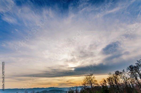 Obraz Dramatic sky with wispy clouds and distant hills at sunset