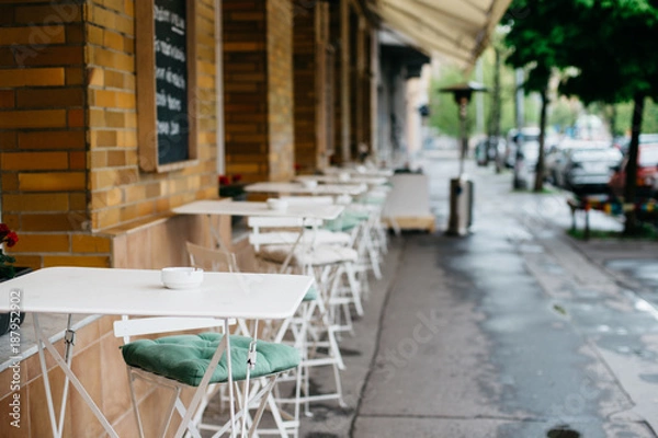 Obraz Cafe with empty tables and chairs outdoors