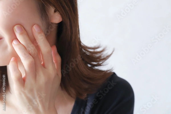 Fototapeta 頬を指で押さえる女性のクローズアップ　肌トラブルと敏感肌のイメージ