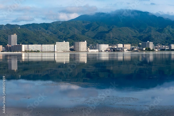 Obraz 早朝の静かな琵琶湖　大津市のマンション群と雲が湖面に映る風景