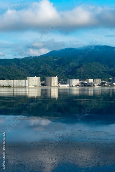 Obraz 早朝の静かな琵琶湖　大津市のマンション群と雲が湖面に映る風景