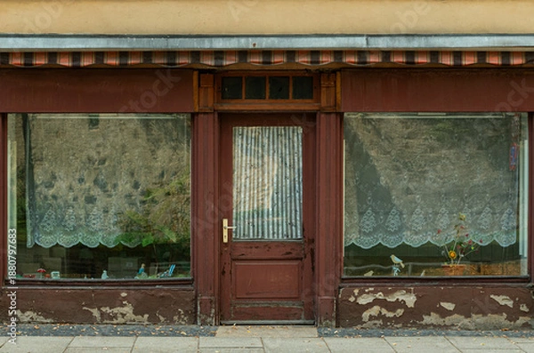 Obraz Old closed storefront with weathered facade and large display windows