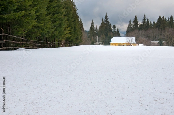 Obraz Yellow house in winter forest. Forest ranger house among deep snowdrifts in the forest.