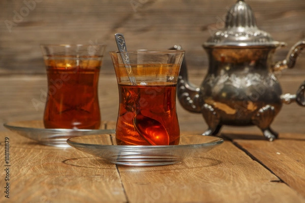 Fototapeta Turkish tea in traditional glass on a wooden table close-up.
