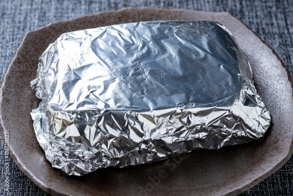 Obraz ローストビーフ調理シーン。アルミホイルで包んで保温している。