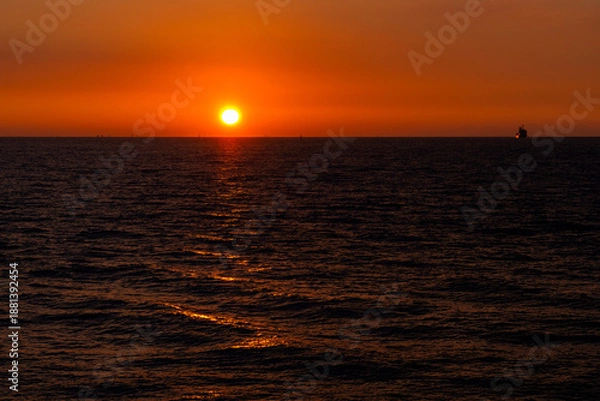 Obraz 海からの日の出と朝焼けの波間と水平線20240105