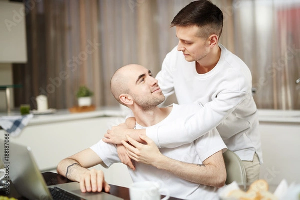 Fototapeta Młodzi kochankowie homoseksualni patrzą na siebie w objęciach w domu