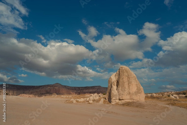 Obraz panorama of a desert valley with a large stone and floating clouds
