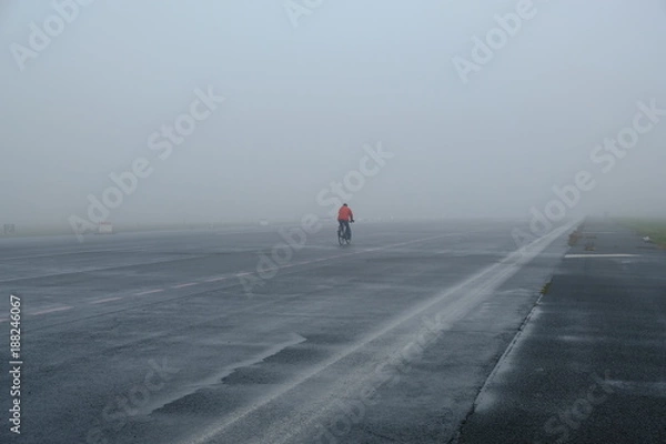 Obraz cyclist on empty and foggy road