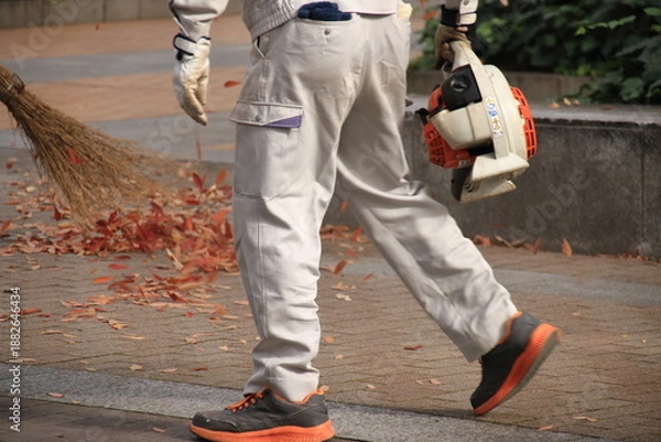 Obraz 公園で紅葉した落ち葉の清掃をする人(横長)