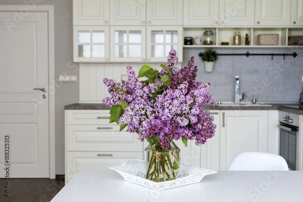 Fototapeta bouquet of purple lilac  on a table in the kitchen