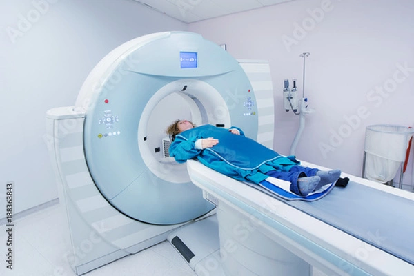 Obraz Female patient undergoing CT - Computerized Tomography Scan in Hospital. Patient wearing lead apron to   cover vital organs.